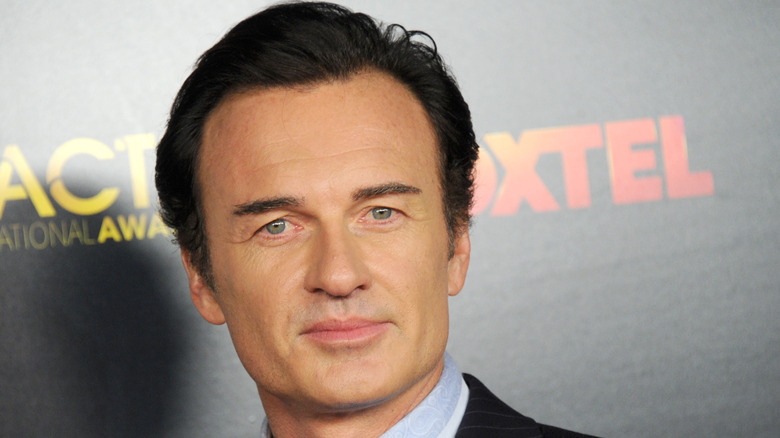 Julian McMahon posing for photos in a suit