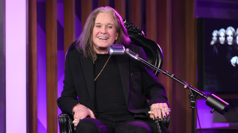 Ozzy Osbourne smiling in front of a microphone