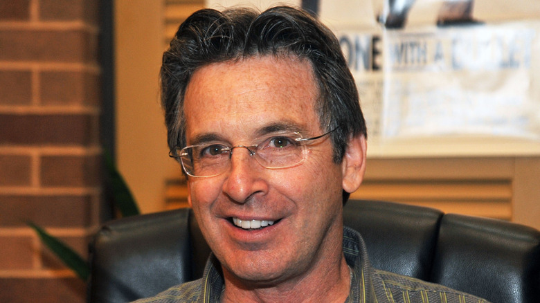 Robert Carradine smiling in glasses