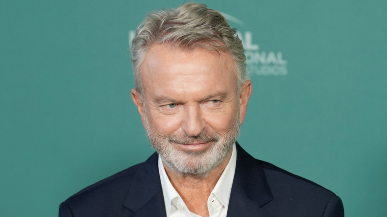 Sam Neill smiling mischievously