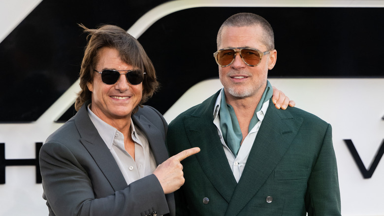 Tom Cruise points at Brad Pitt