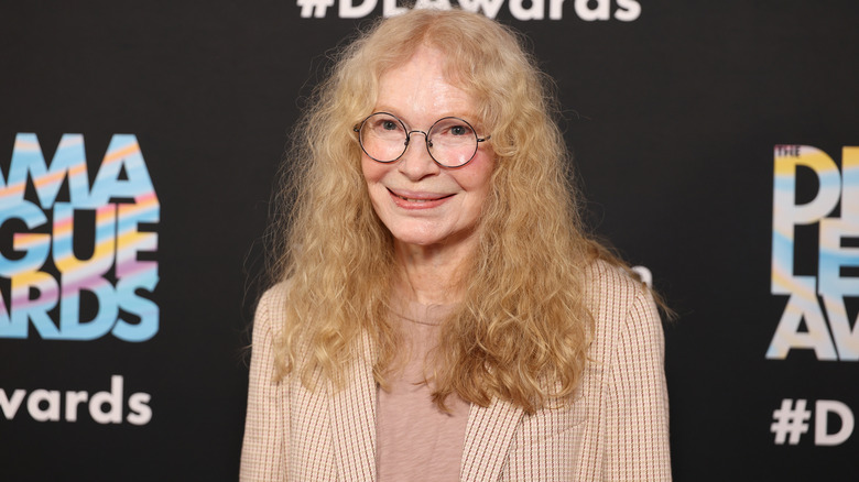 Mia Farrow smiling in glasses at an event