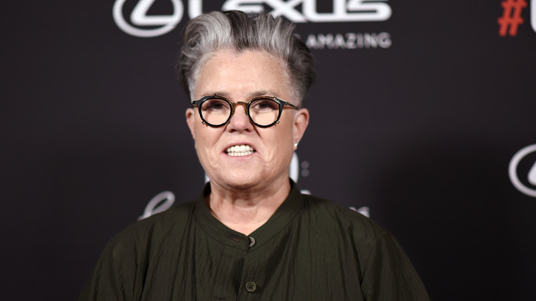 Rosie O'Donnell posing for photos in glasses and a dark button-up shirt