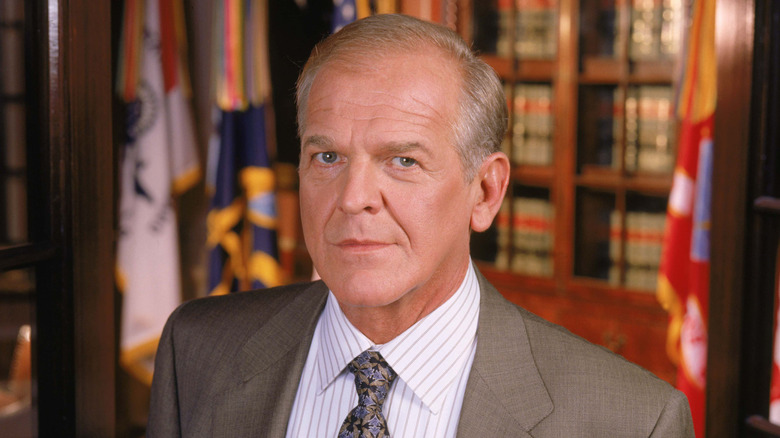 John Spencer standing in front of law books