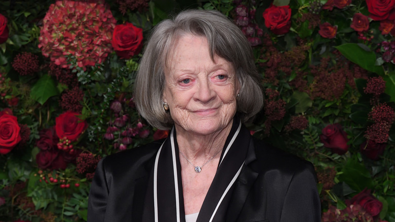 Maggie Smith posing in front of flowers
