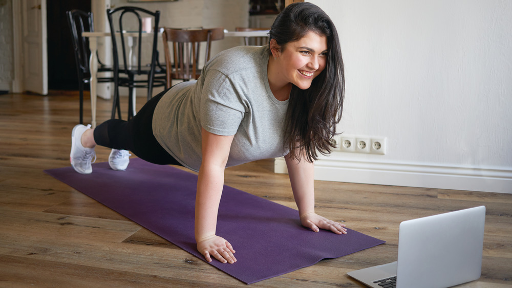 A woman planking on a purple mat