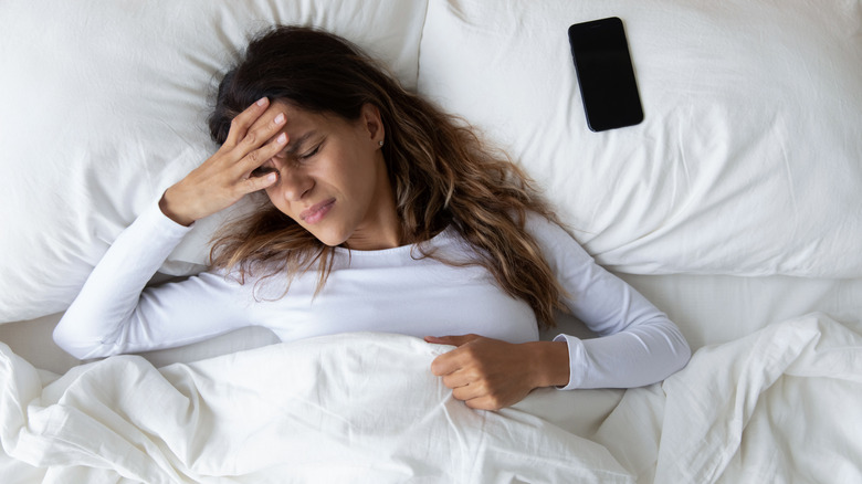 Woman sleeping next to cell phone