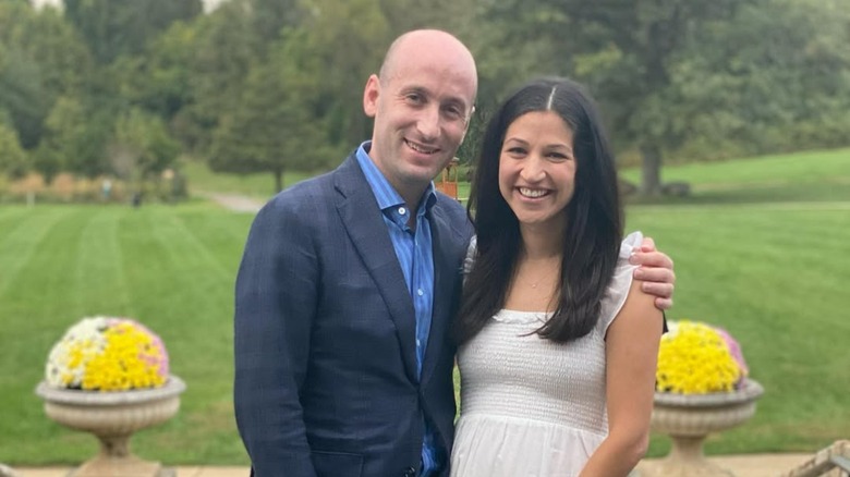 Stephen Miller and Katie Miller smiling while posing for a photo together outside
