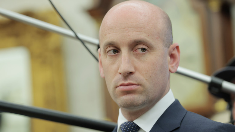 Stephen Miller giving someone some serious side-eye in a grey suit
