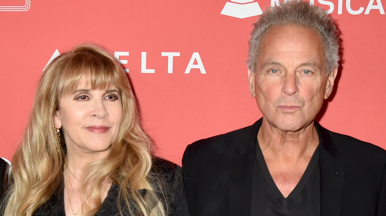 Stevie Nicks and Lindsey Buckingham against orange background