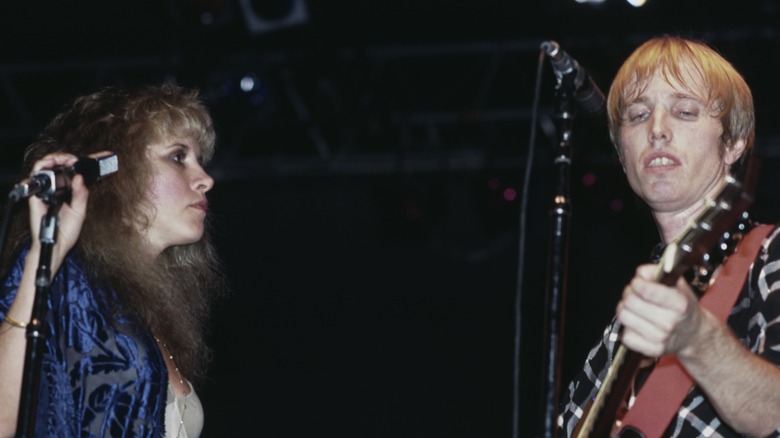 Stevie Nicks performing on stage with Tom Petty playing a guitar.