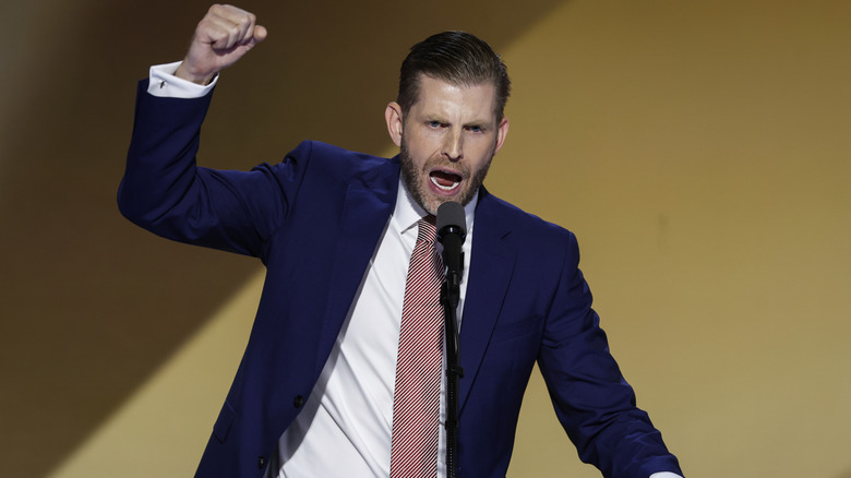 Eric Trump raising his fist as he delivers an impassioned speech