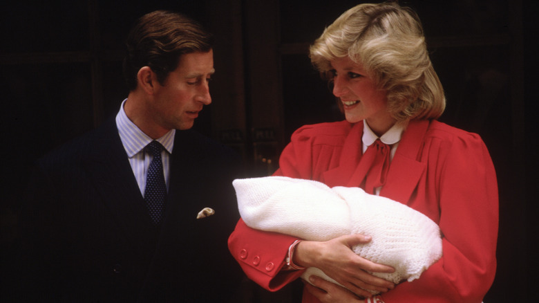 Princess Diana cradling Prince Harry with King Charles