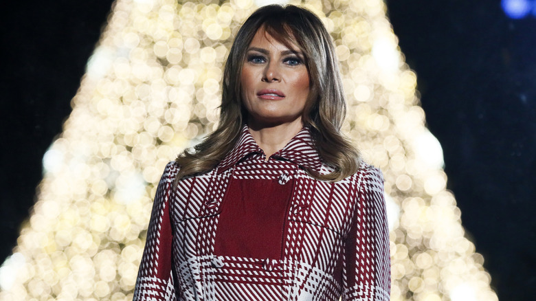 Melania Trump standing in front of a Christmas tree