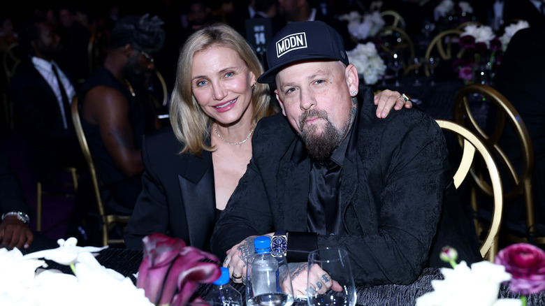 Cameron Diaz and Benji Madden posing for photos in black suits