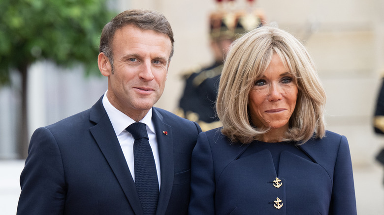 The Macrons in navy blue suits, smiling