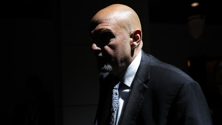 A dark, heavily contrasted photo of John Fetterman.