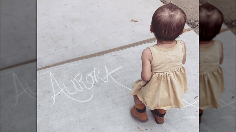 Troian Bellisario and Patrick J. Adams's daughter on sidewalk beside her name written in chalk