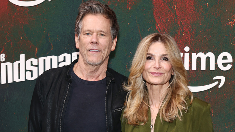 Kevin Bacon posing at an event with his wife, Kyra Sedgwick