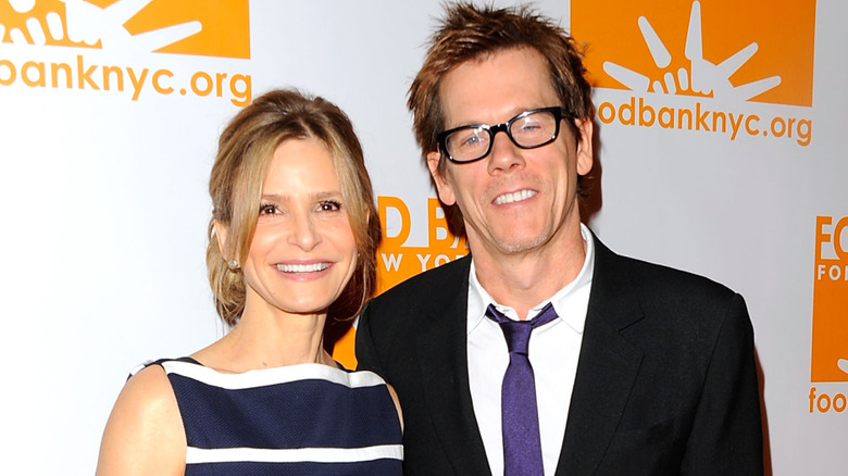 Kyra Sedgwick and Kevin Bacon smiling while posing at an event together