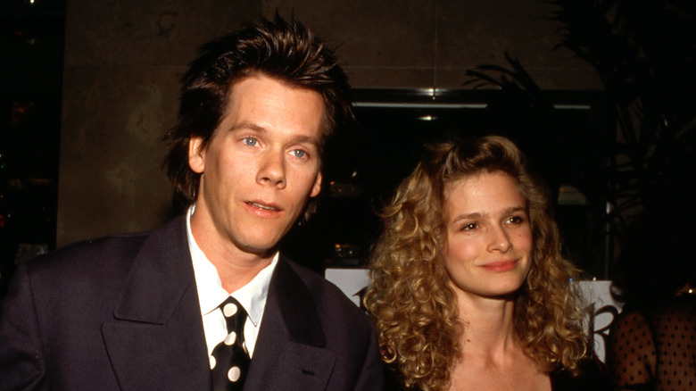 Kevin Bacon walking next to a smiling Kyra Sedgwick