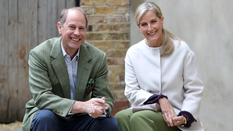 Prince Edward and Duchess Sophie sitting on the steps of a farm