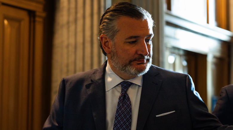 Ted Cruz looking down and despondent in a navy suit