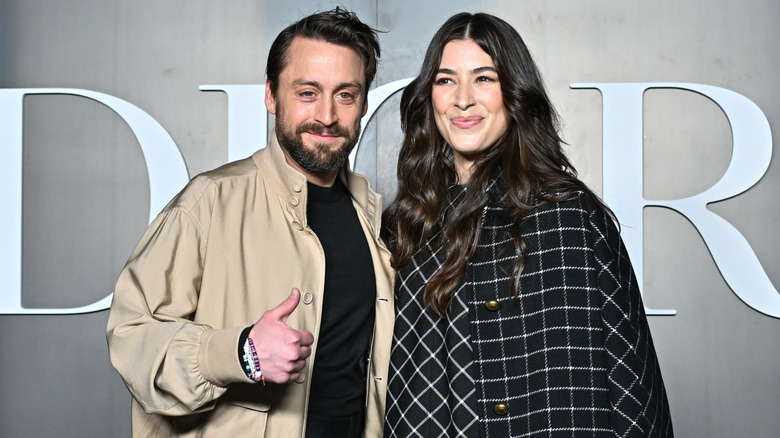 Kieran Culkin giving a 'thumbs up' with arm around Jazz Charton