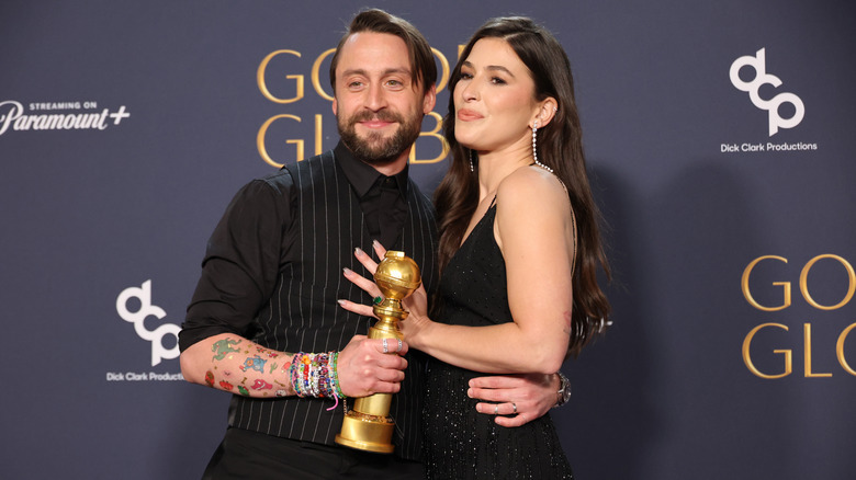 Kieran Culkin holding Golden Globe arm around Jazz Charton