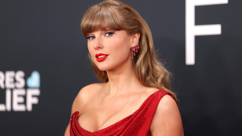 Taylor Swift posing on the red carpet at the 2025 Grammys in a red dress