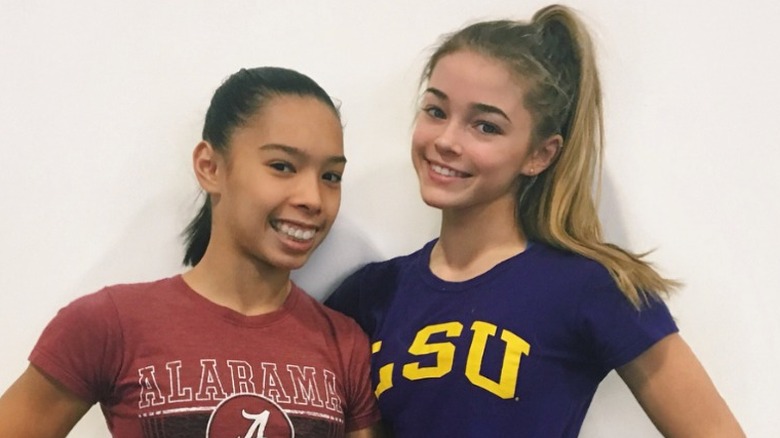 Olivia Dunne in LSU shirt posing for photo with friend