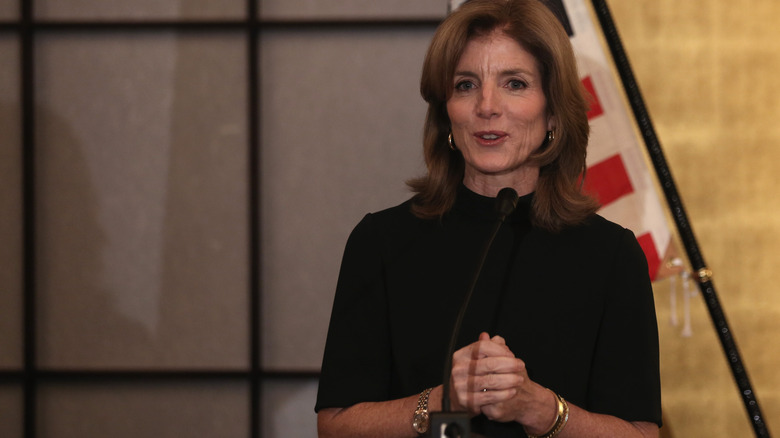 Caroline Kennedy speaking with an American flag in the background