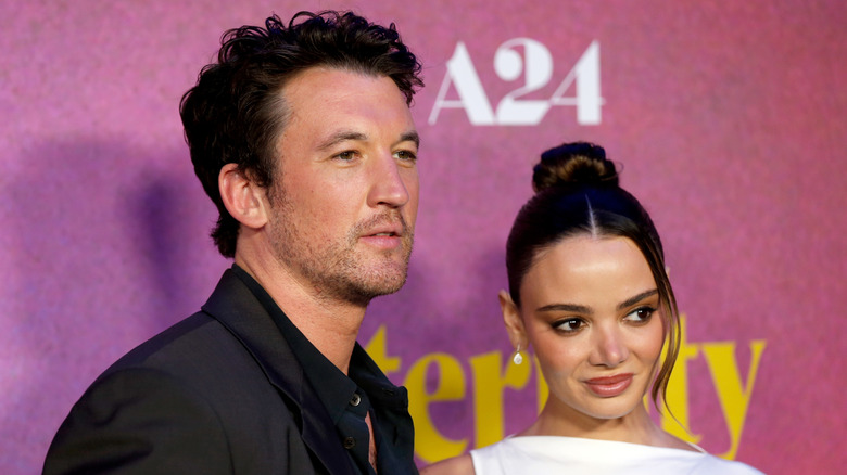 Closeup of Miles Teller and Keleigh Sperry posing on step-and-repeat