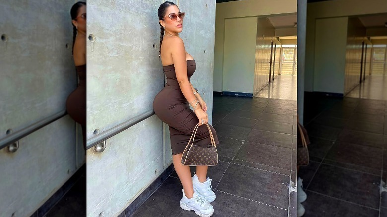 Woman in brown tube dress and white sneakers