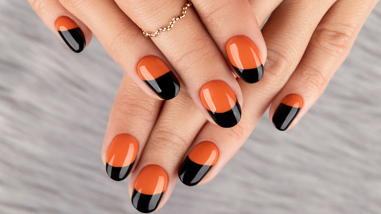 Orange and black-painted nails