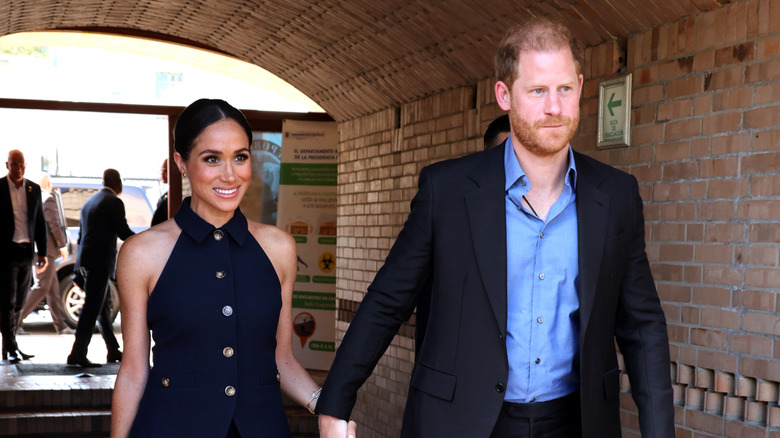 Prince Harry and Meghan Markle holding hands as they walk side by side