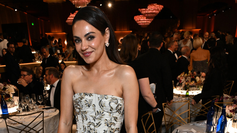 Mila Kunis (in a sleeveless white dress) at the 2026 Golden Globe Awards