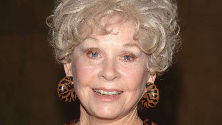 Sue Ane Langdon wearing brown and black earrings.