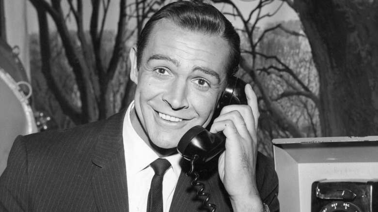 Sean Connery smiling and holding a telephone/