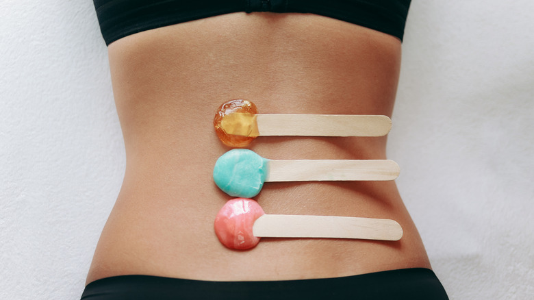 sticks with wax on woman's back