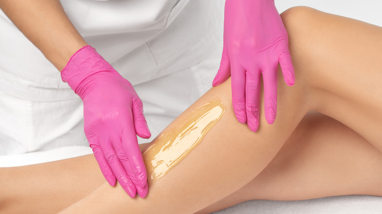 Esthetician applying sugaring mixture