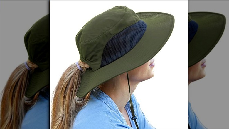 woman wearing safari green sun hat with ponytail opening 