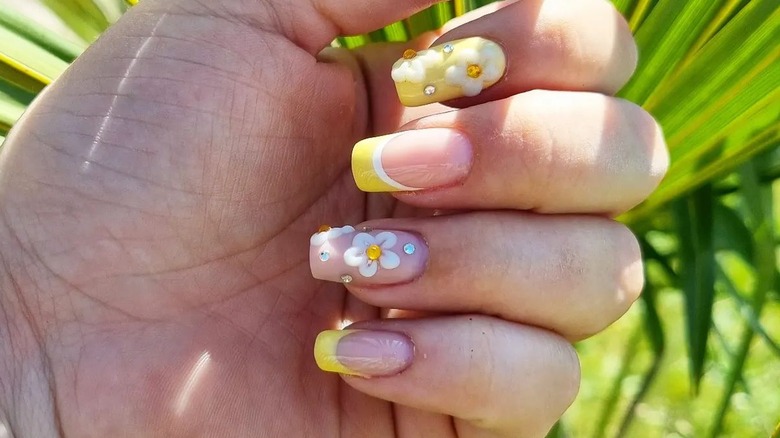 Hand with daisy nail art 