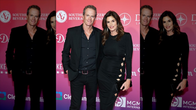 Rande Gerber and Cindy Crawford posing together at a Valentine's Day event in all black outfits