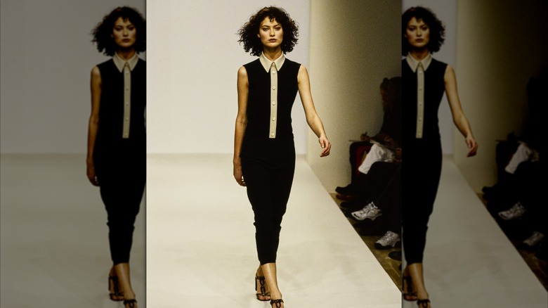 Shalom Harlow in a black dress walking the runway