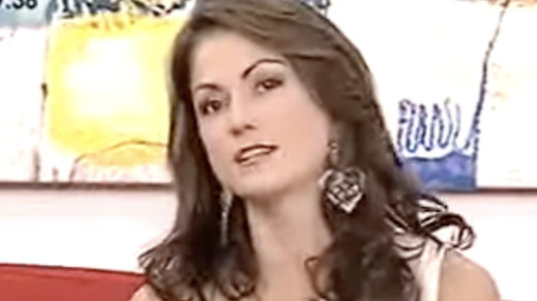 Lina Marulanda wearing a one-shoulder top while speaking on television