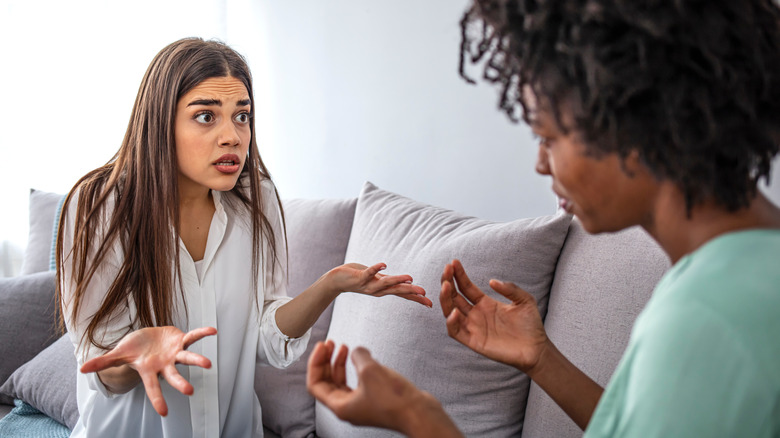 Two women arguing on sofa