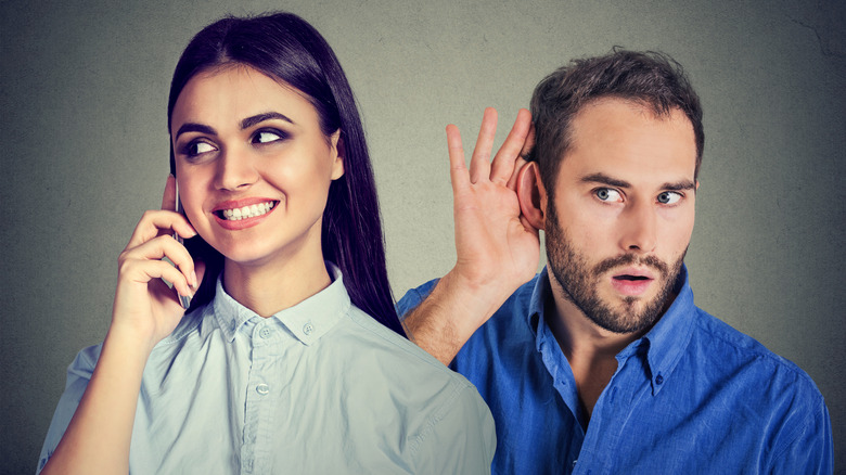 A woman gossiping to a man