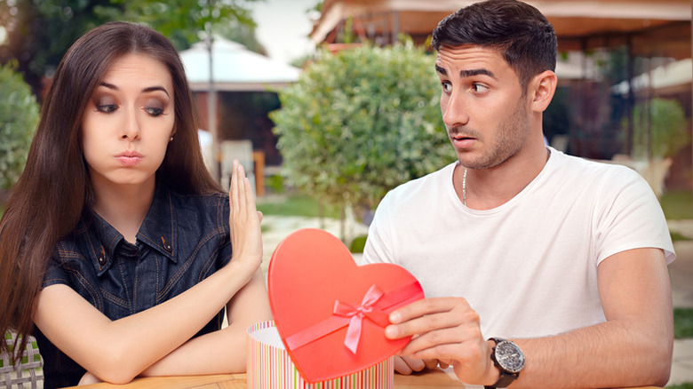 A woman refusing a present from a man