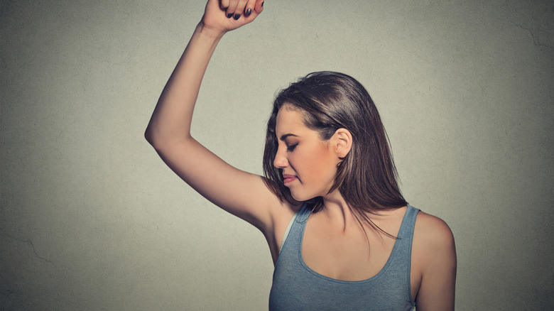 Woman sniffing her arm